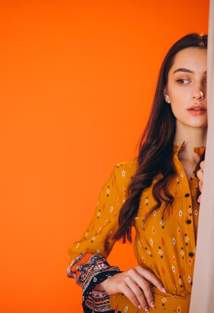 Young woman in a beautiful yellow dress in studio